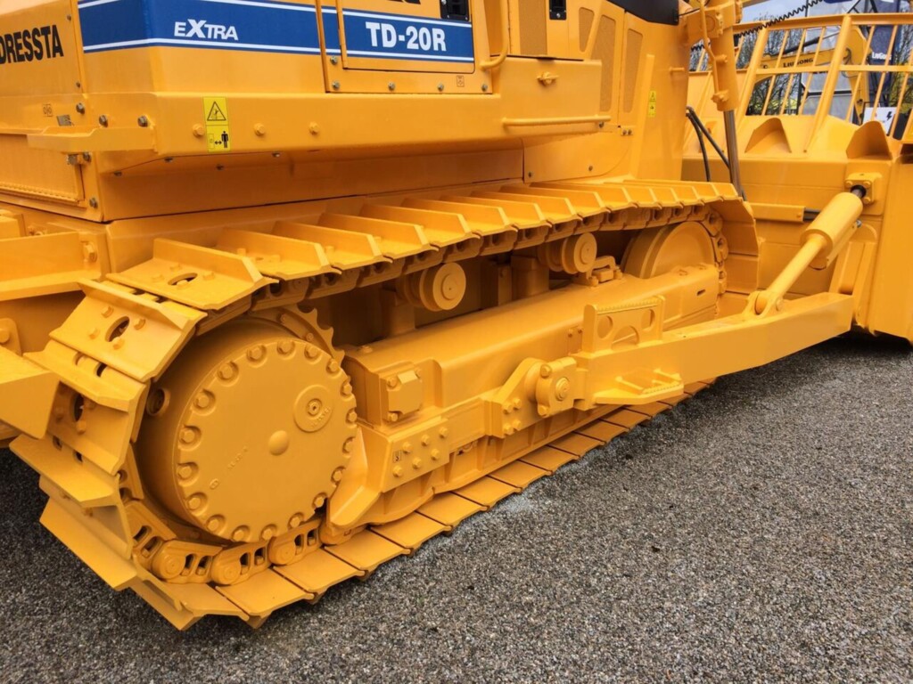 Жовта гусенична ходова частина від будівельної машини типу бульдозера.