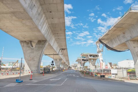 Конструкція мосту в процесі будівництва, з видимими опорами та частково завершеними секціями мосту.
