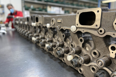 Ряд головок циліндрів двигуна крупним планом в процесі складання на заводі.