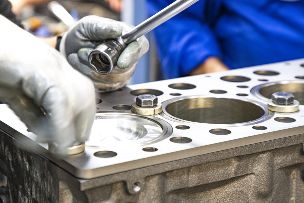 Процес встановлення гільз циліндрів на двигун крупним планом.