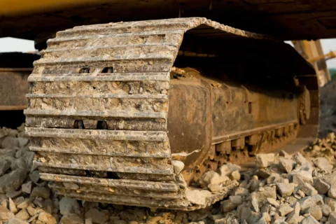 Зношені гусениці екскаватора, що працює на кам'янистому ґрунті - приклад інтенсивного зносу гусеничної ходової частини